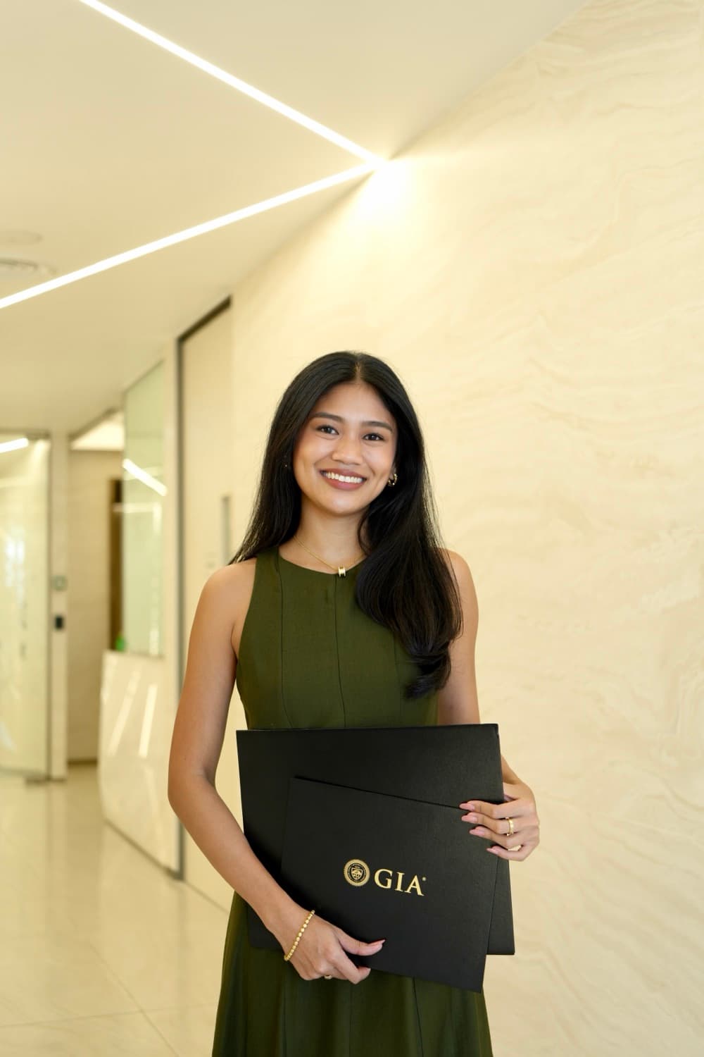 April, founder of GemBridge and GIA Graduate Gemologist, holding her GIA diploma